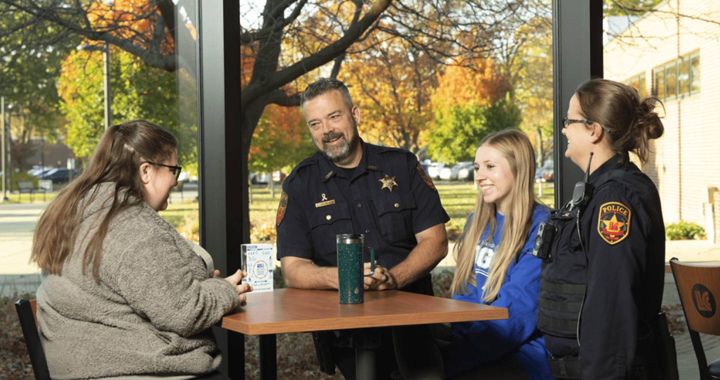 two police officers talking casually with two students