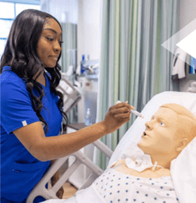 Amaris Gaines working with mannequin in nursing skills lab